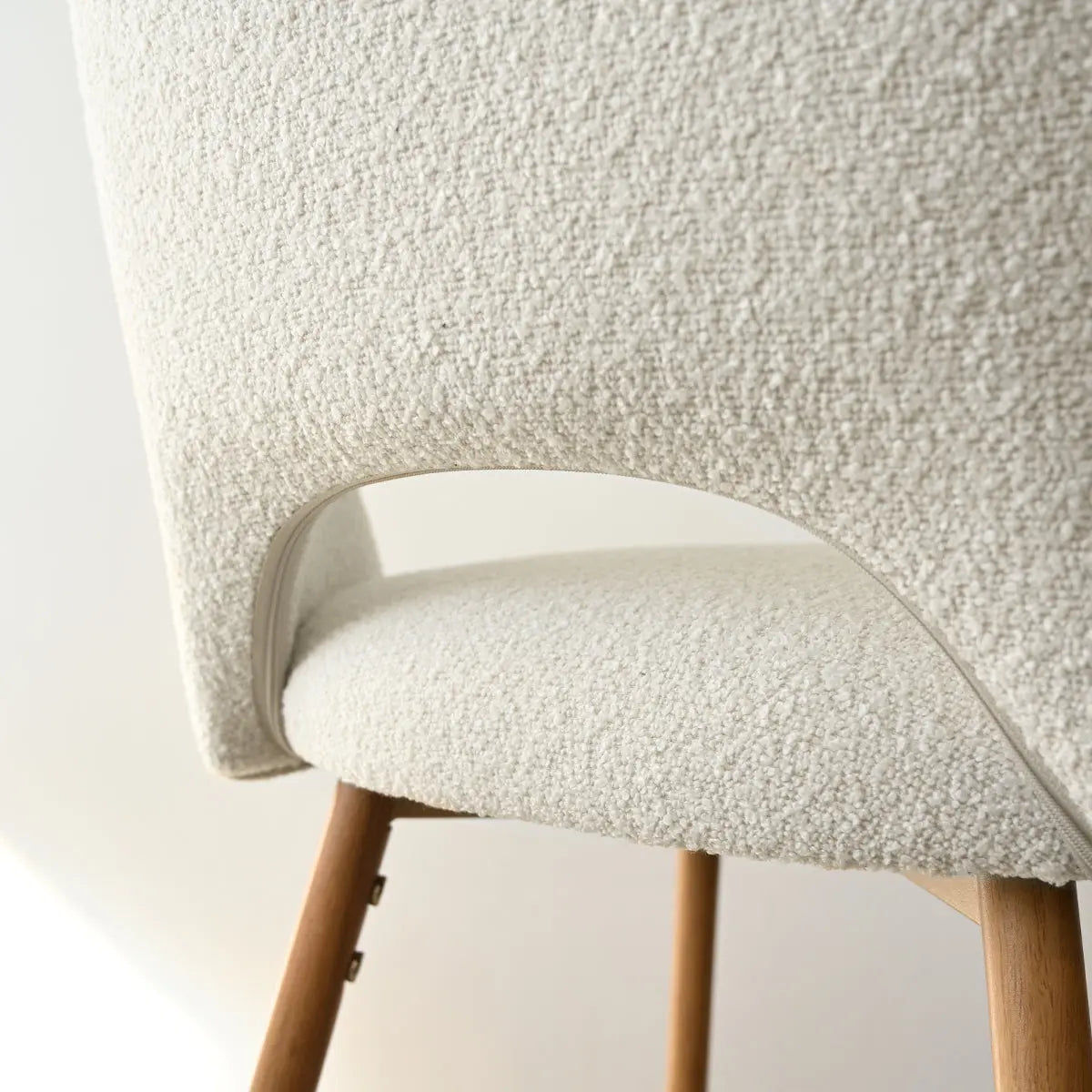 Close-up of Edwin Modern Boucle Counter Stool with oak legs, textured upholstery, minimalist design.