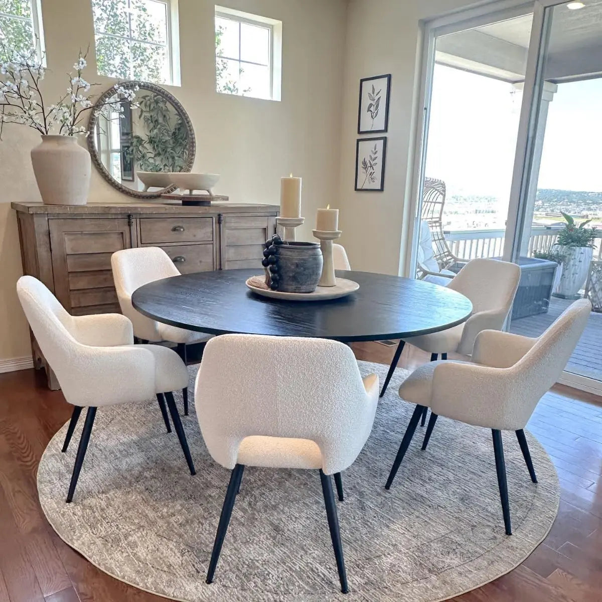 Edwin Modern Upholstered Dining Chairs with arms, round table, light walls, wooden sideboard, hardwood floor.