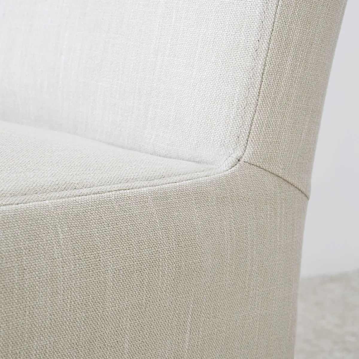 Close-up of North Beige Upholstered Dining Chair fabric texture, emphasizing removable slipcovers design.