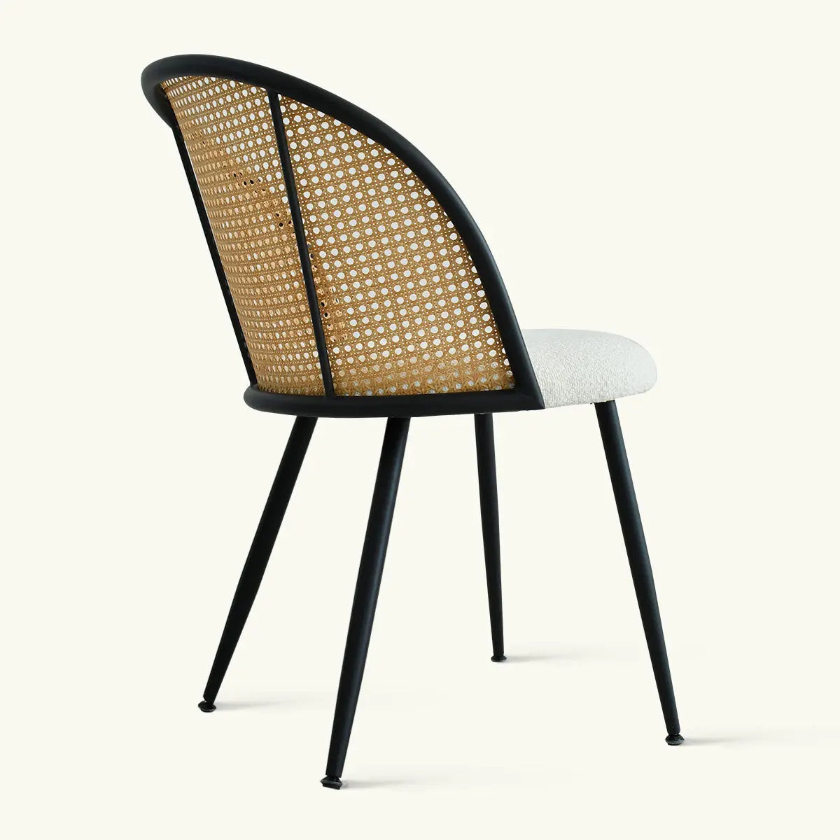 Oliver & Jules rattan dining chair with black legs, beige cushion, no background details.