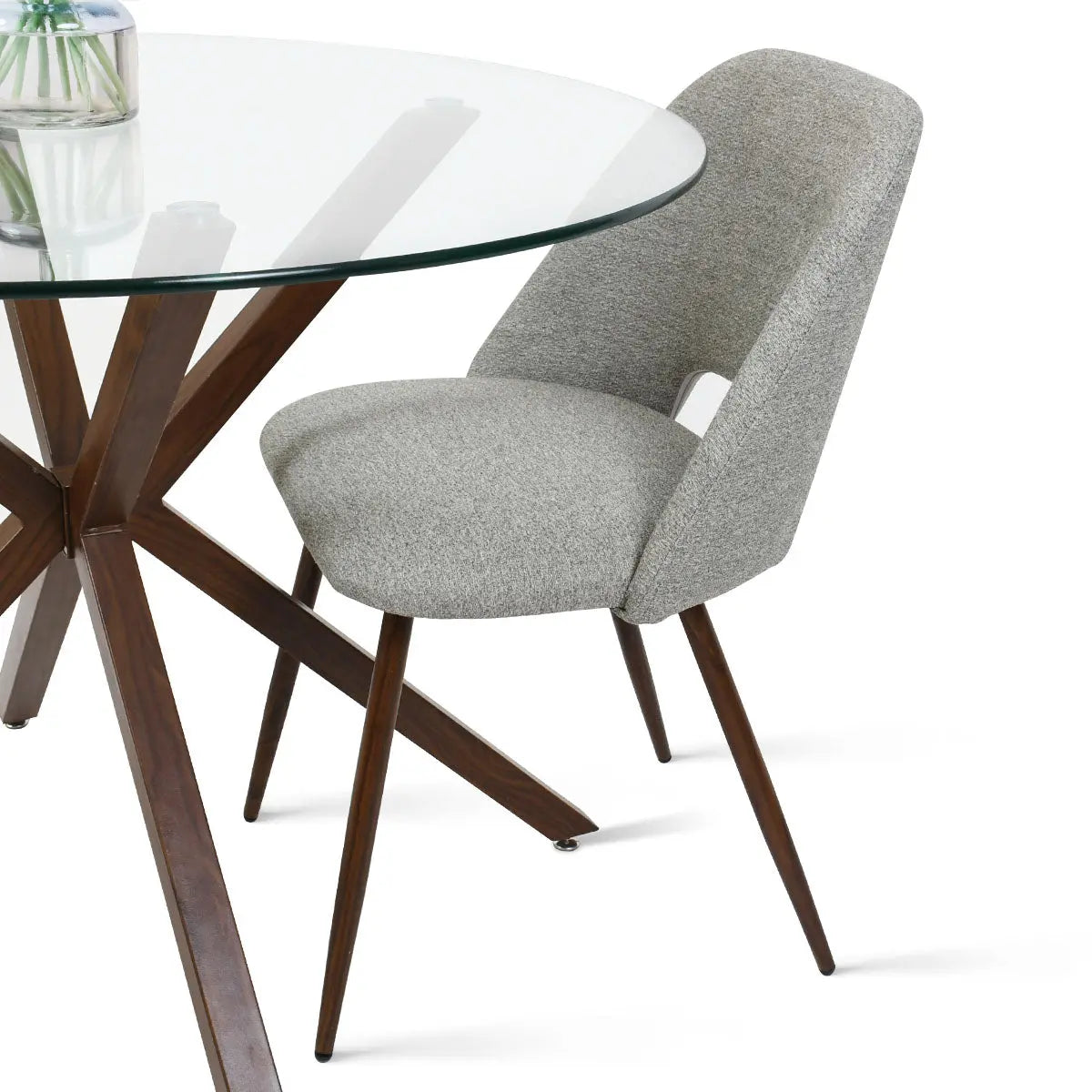 Oliver & Edwin round glass dining table set with gray upholstered chair and wood base.