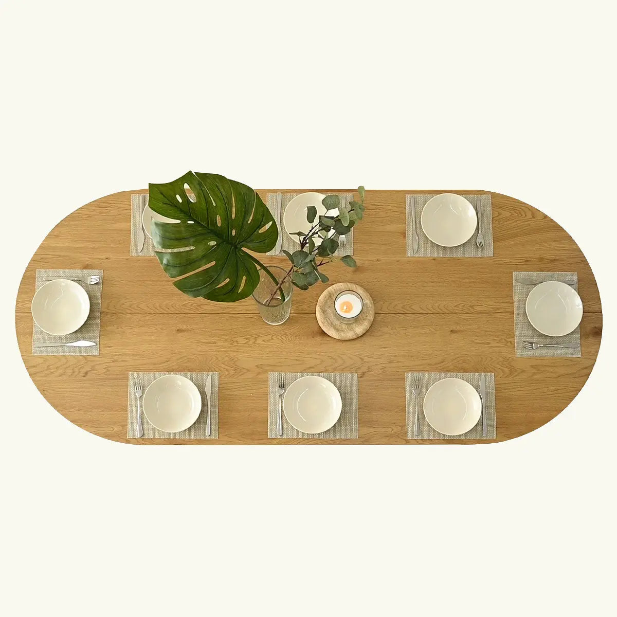 Top view of the Dwen Modern Oval Dining Table set with white plates and silverware.