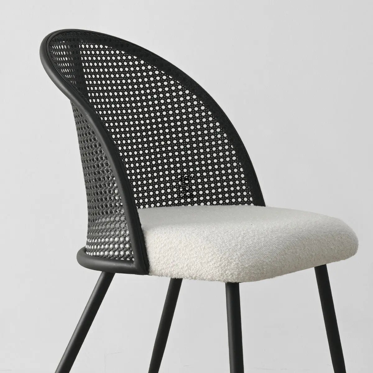 Lucca Black Rattan Boucle Dining Chair with sleek modern design and comfortable cushioned seat.
