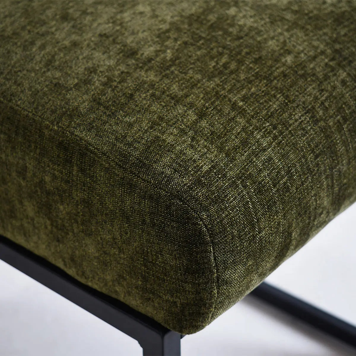 Close-up of green upholstered seat on Mason modern metal frame counter stool without additional decor.