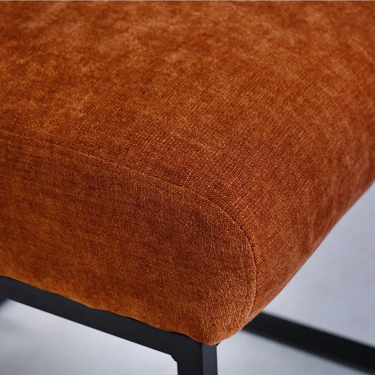 Close-up of Mason Modern upholstered counter stool with metal frame in rich brown fabric.