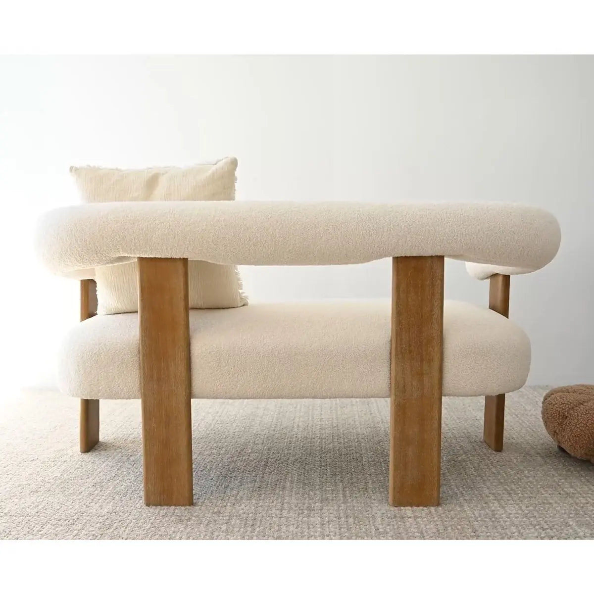 Maye beige loveseat sofa with wooden legs, neutral carpet; ideal modern seating for living rooms.