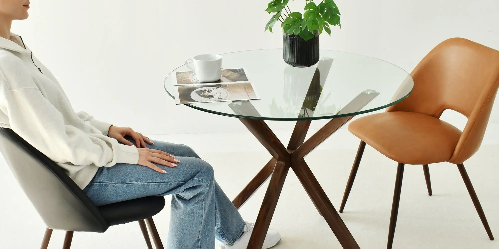 Oliver Modern Round Glass Dining Table, brown chair, black chair, minimalist room, stylish seating.