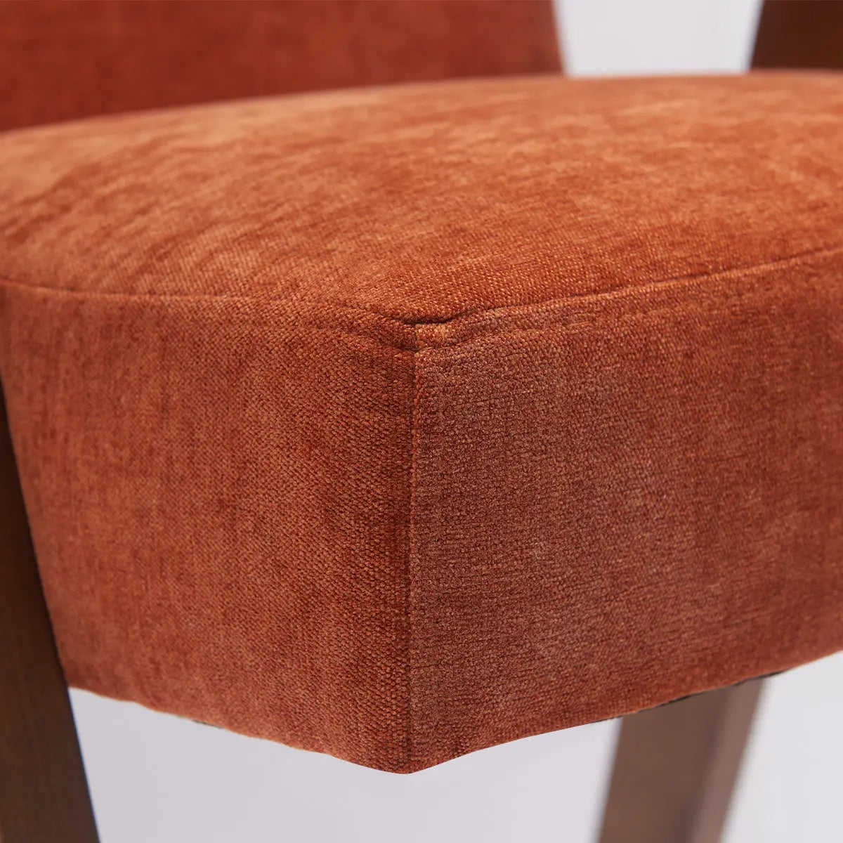 Morgan Mid Century Modern Upholstered Counter Stool with arms, close-up of rust-colored fabric.